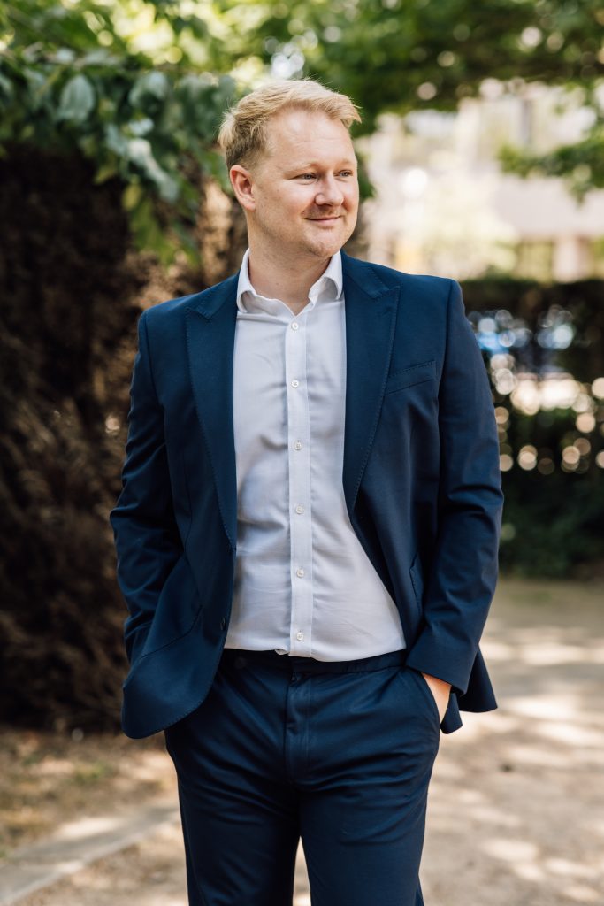 Man in suit standing outdoors.